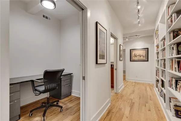 a view of a workspace with furniture and a book shelf