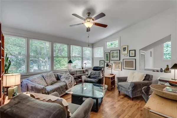 a living room with furniture and a large window with wooden floor