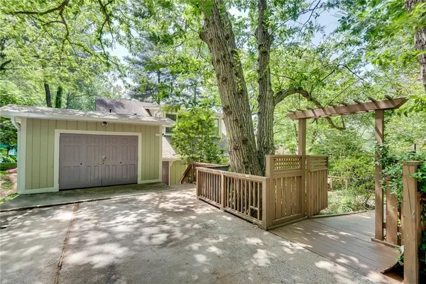 a view of a house with a large tree and wooden fence