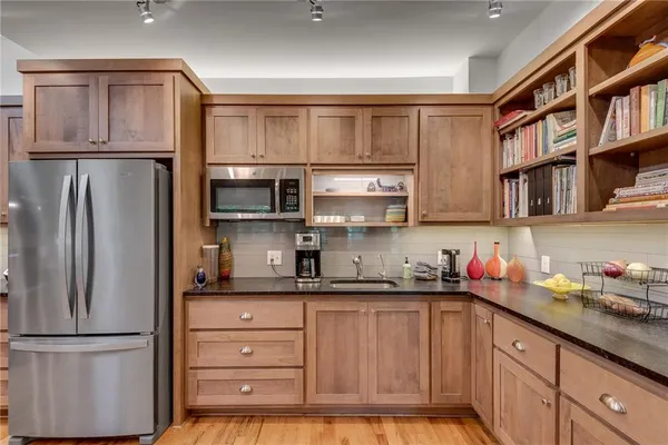 a kitchen with stainless steel appliances granite countertop a refrigerator and a stove top oven