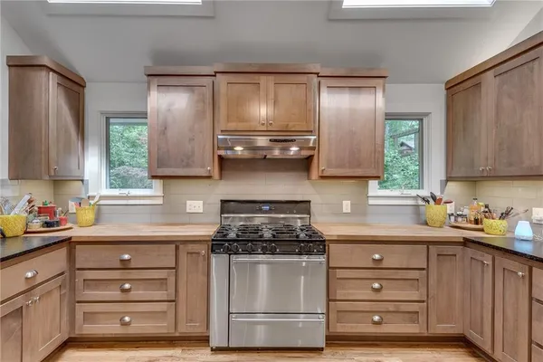 a kitchen with white cabinets and window