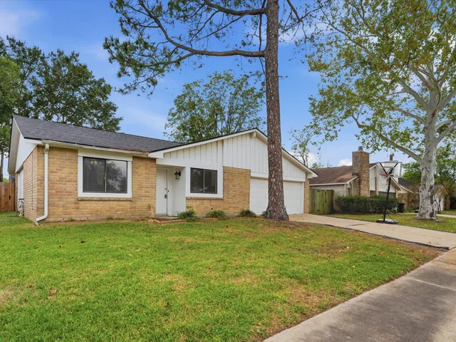 a view of a yard in front of a house with large tree