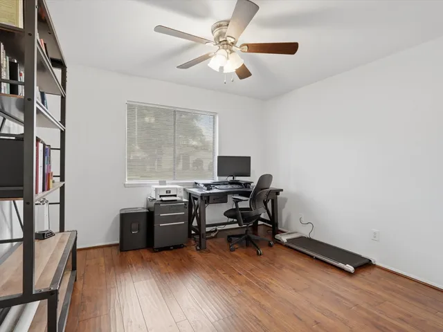 a view of a workspace with furniture and a window