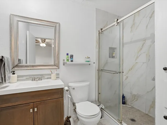 a bathroom with a sink a toilet and shower