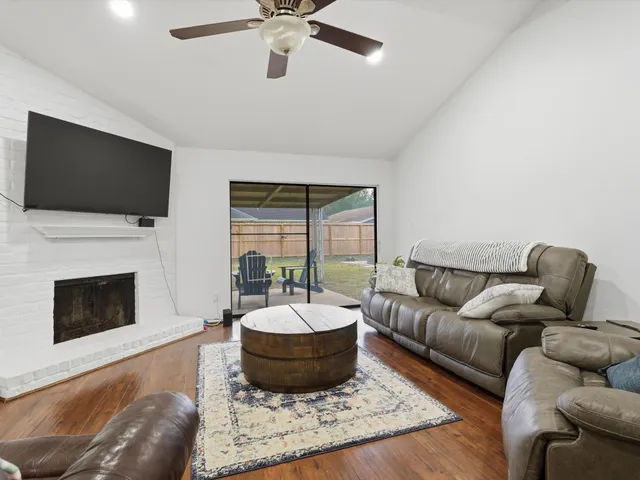 a living room with furniture a flat screen tv and a fireplace