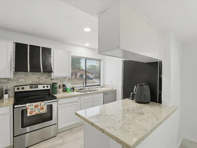 a kitchen with stainless steel appliances granite countertop a stove a sink and a refrigerator