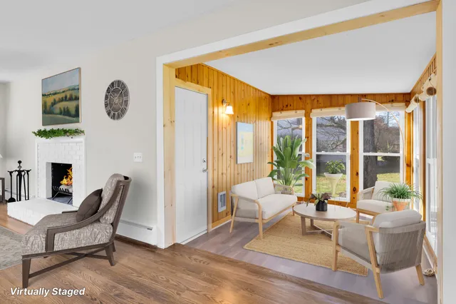 a living room with fireplace furniture and a floor to ceiling window