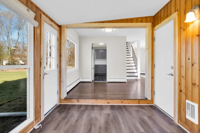 a view of an entryway with wooden floor and door
