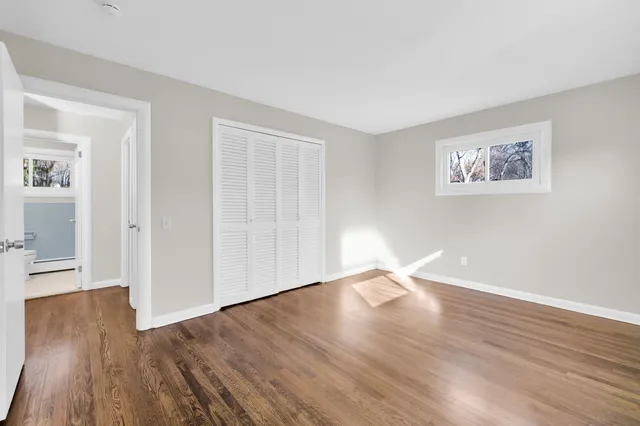 a view of an empty room with wooden floor