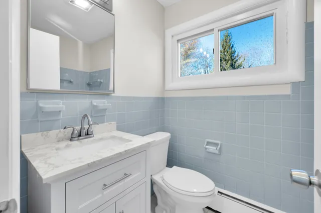 a bathroom with a toilet a sink a vanity and mirror