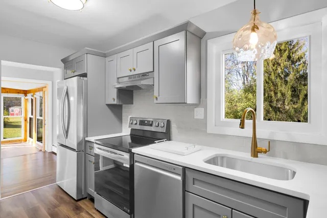 a kitchen with stainless steel appliances a sink stove and refrigerator