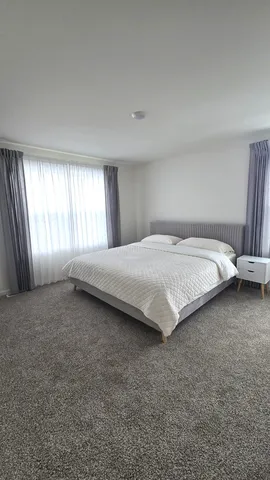 a large bed sitting in a room next to a window