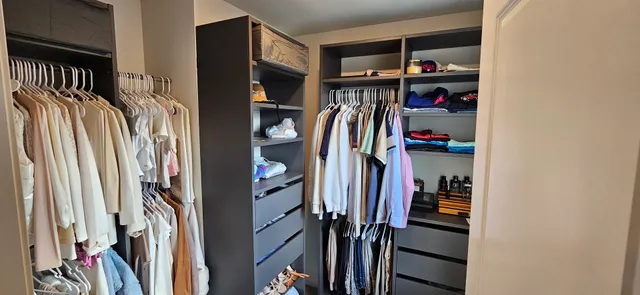 a view of walk in closet with clothes and shoes