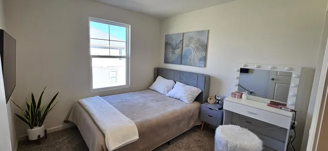 a bedroom with a bed and a window