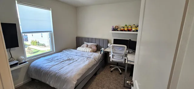 a bed sitting in a bedroom next to a window