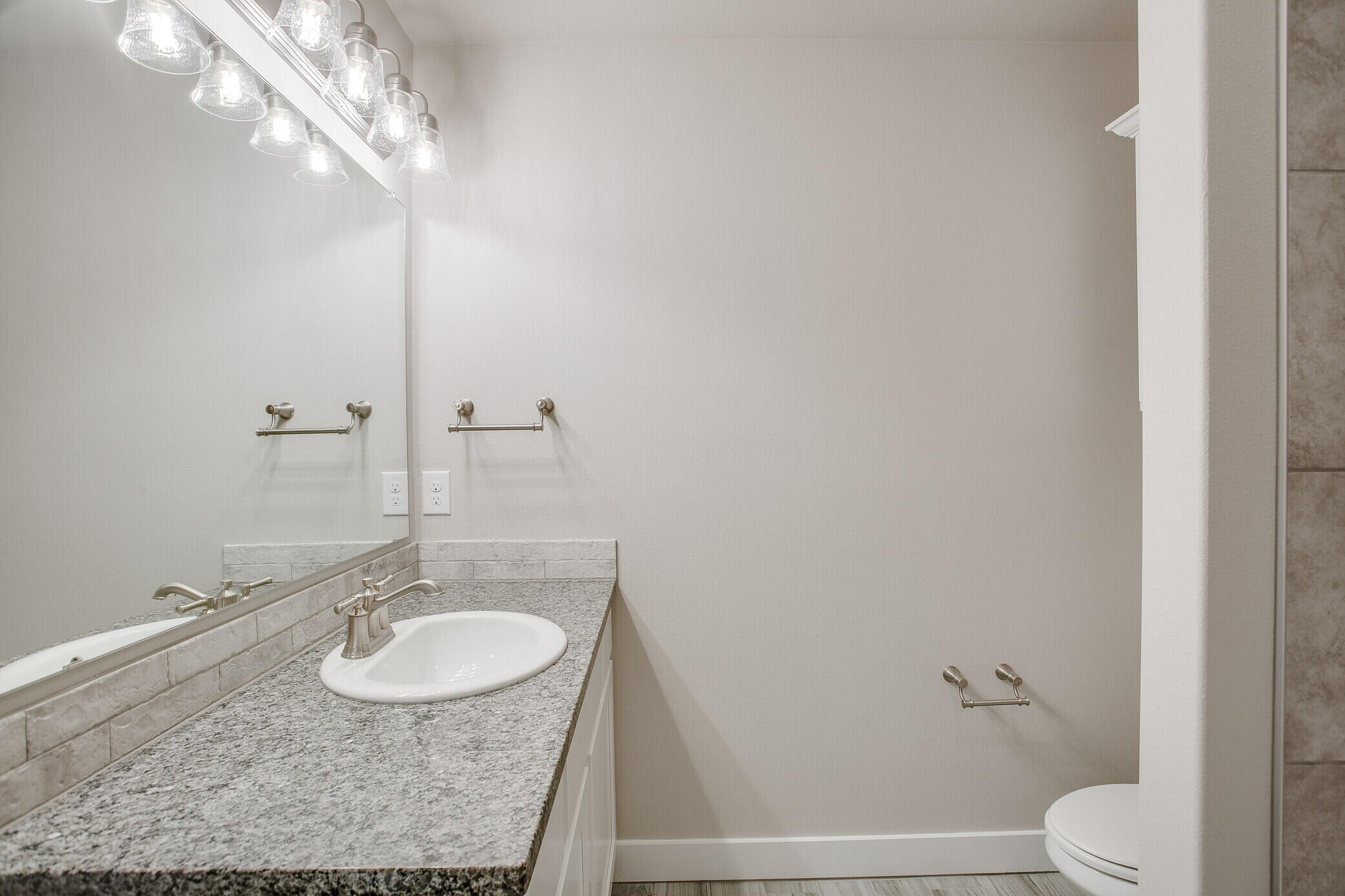 1905 140th Street Lubbock, TX 79423 - Photo 13 of 19 a bathroom with a sink a toilet and a mirror