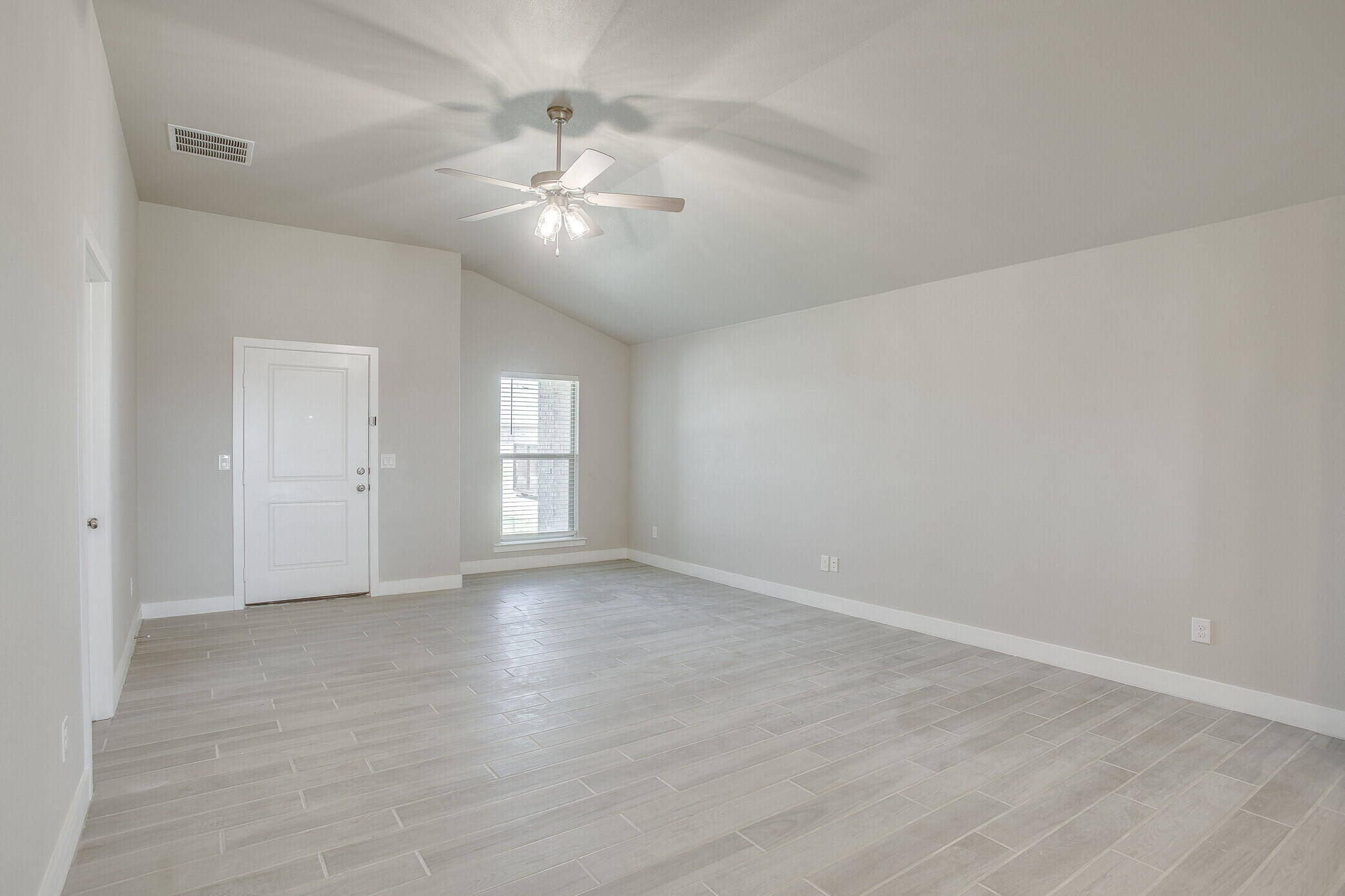 1905 140th Street Lubbock, TX 79423 - Photo 4 of 19 a view of an empty room with chandelier fan and wooden floor