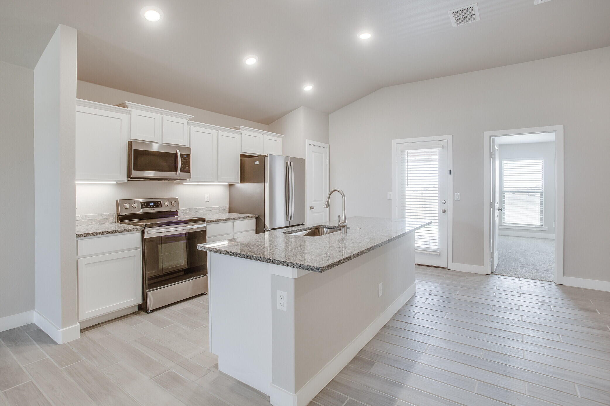 1905 140th Street Lubbock, TX 79423 - Photo 5 of 19 a kitchen with stainless steel appliances kitchen island granite countertop a stove top oven a sink and dishwasher