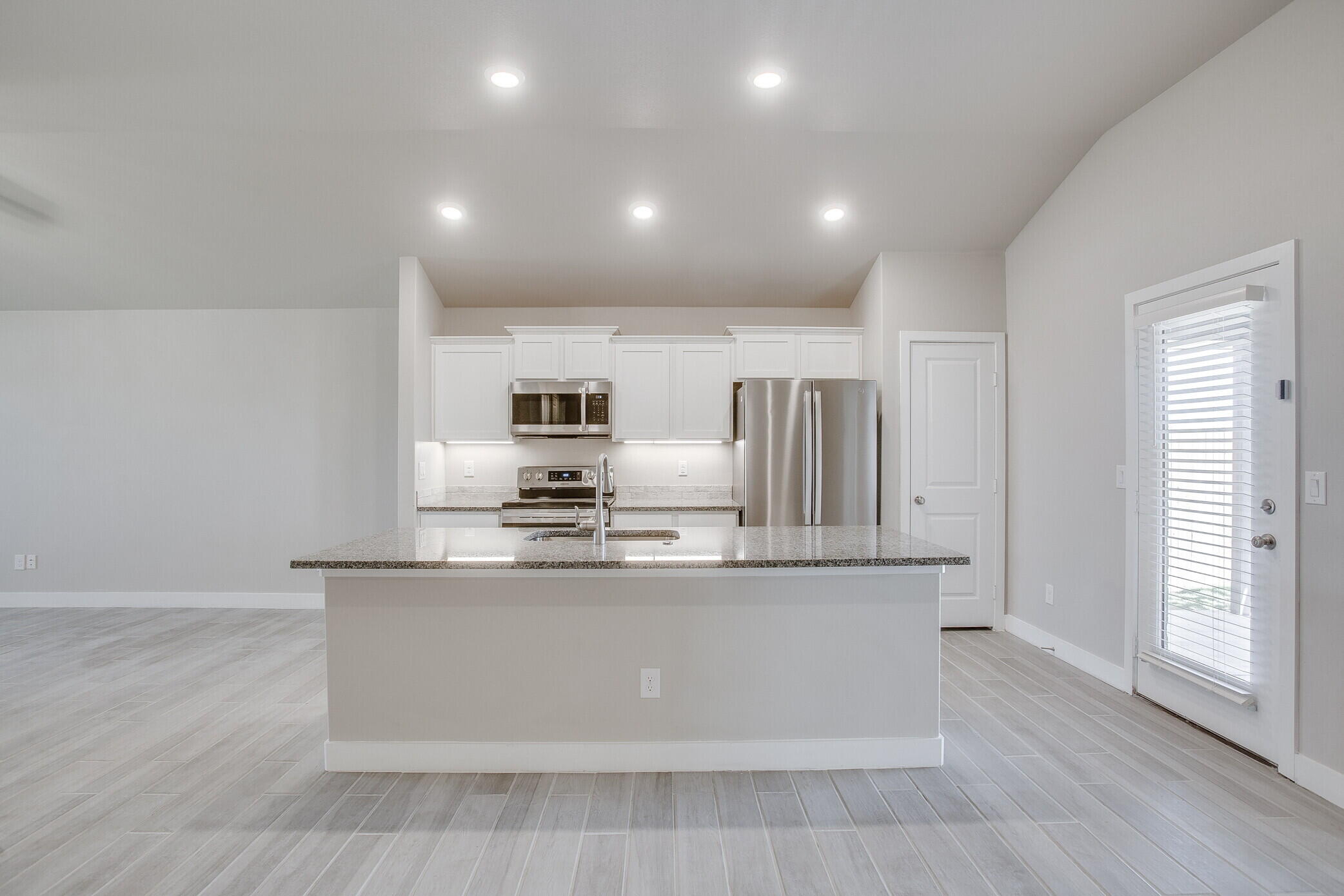 1905 140th Street Lubbock, TX 79423 - Photo 6 of 19 a large kitchen with stainless steel appliances a large counter top and a wooden floors