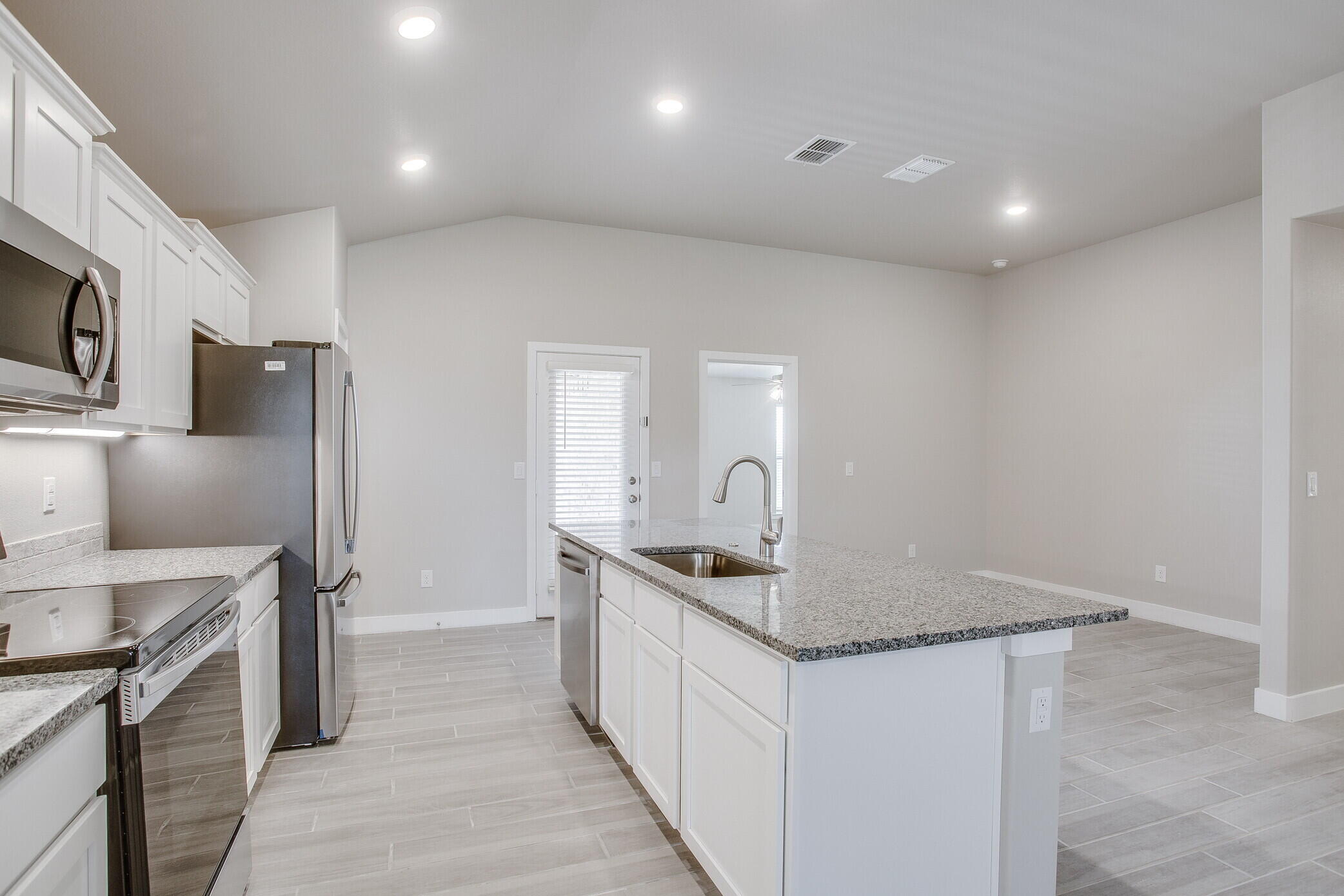 1905 140th Street Lubbock, TX 79423 - Photo 7 of 19 a kitchen with stainless steel appliances granite countertop a sink stove and refrigerator