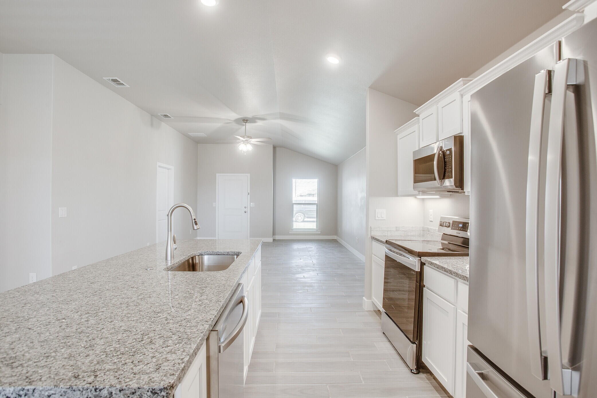 1905 140th Street Lubbock, TX 79423 - Photo 8 of 19 a kitchen with stainless steel appliances granite countertop a sink stove and refrigerator