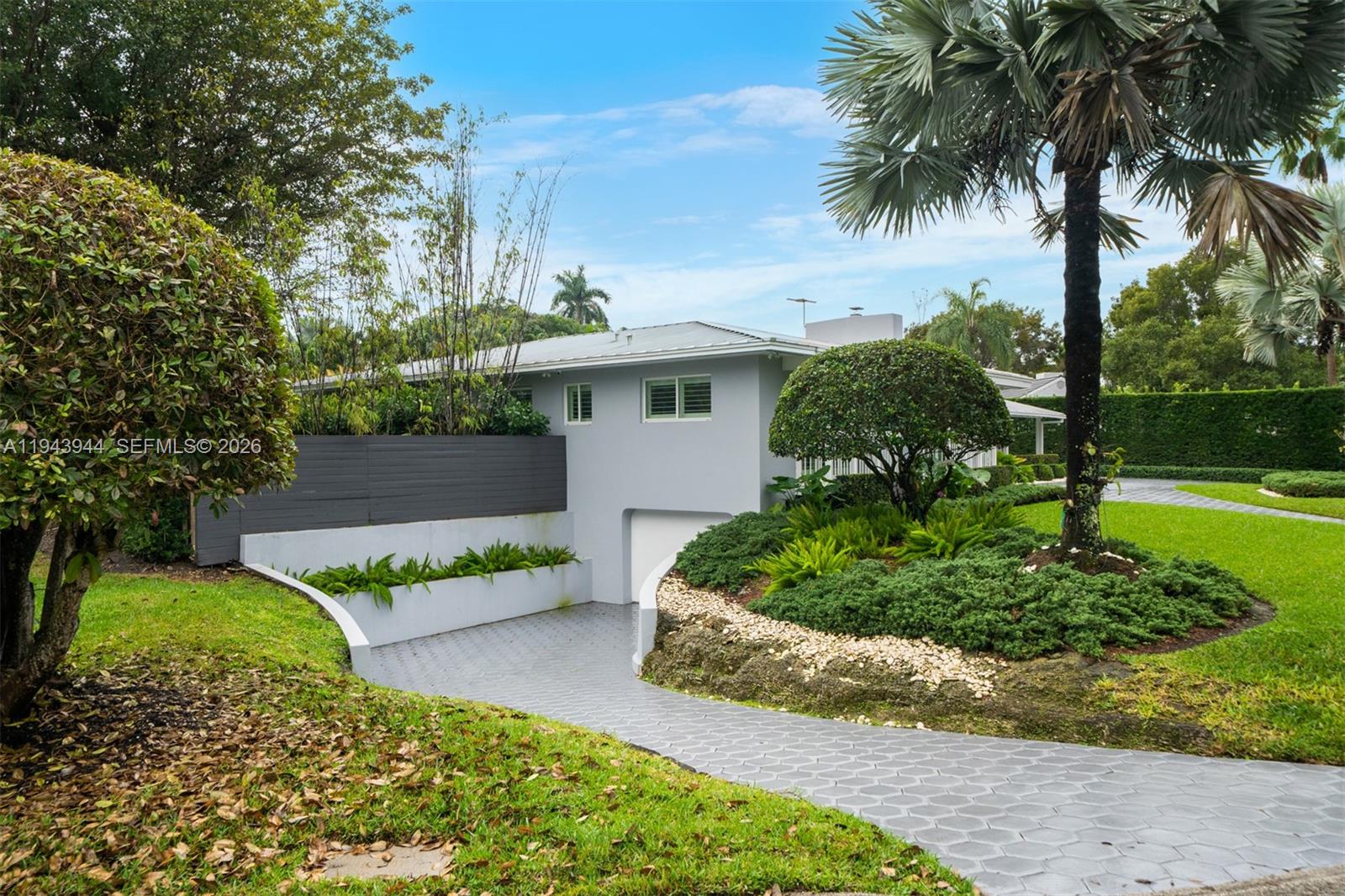 13333 Southwest 59th Court Pinecrest, FL 33156 - Photo 16 of 16 a front view of a house with a yard and a garage
