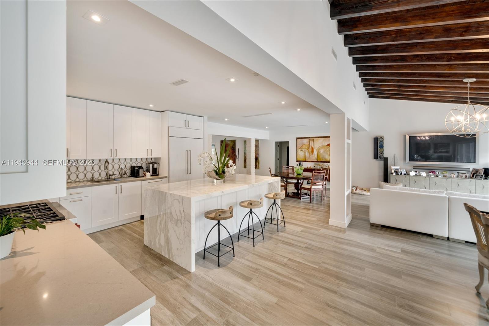 13333 Southwest 59th Court Pinecrest, FL 33156 - Photo 8 of 16 a large white kitchen with lots of counter space a sink a window and chairs