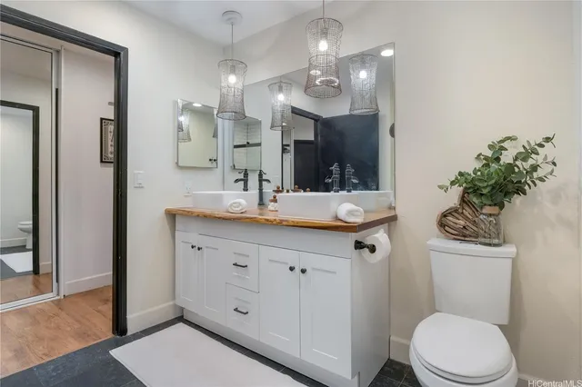 a bathroom with a sink a toilet and a mirror