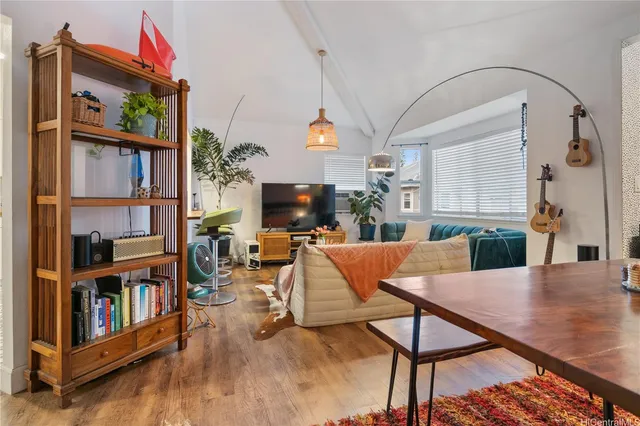 a living room with furniture a bookshelf and a flat screen tv