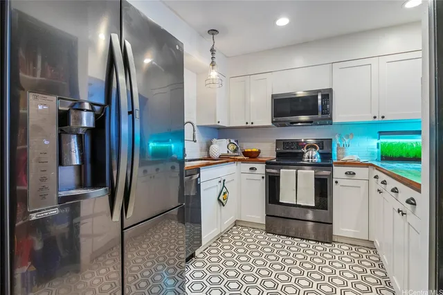 a kitchen with stainless steel appliances granite countertop a refrigerator a stove and a sink