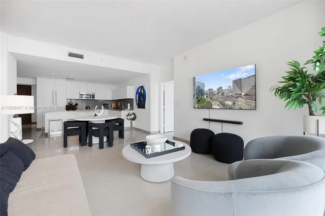 a living room with fireplace furniture and a dining table with wooden floor