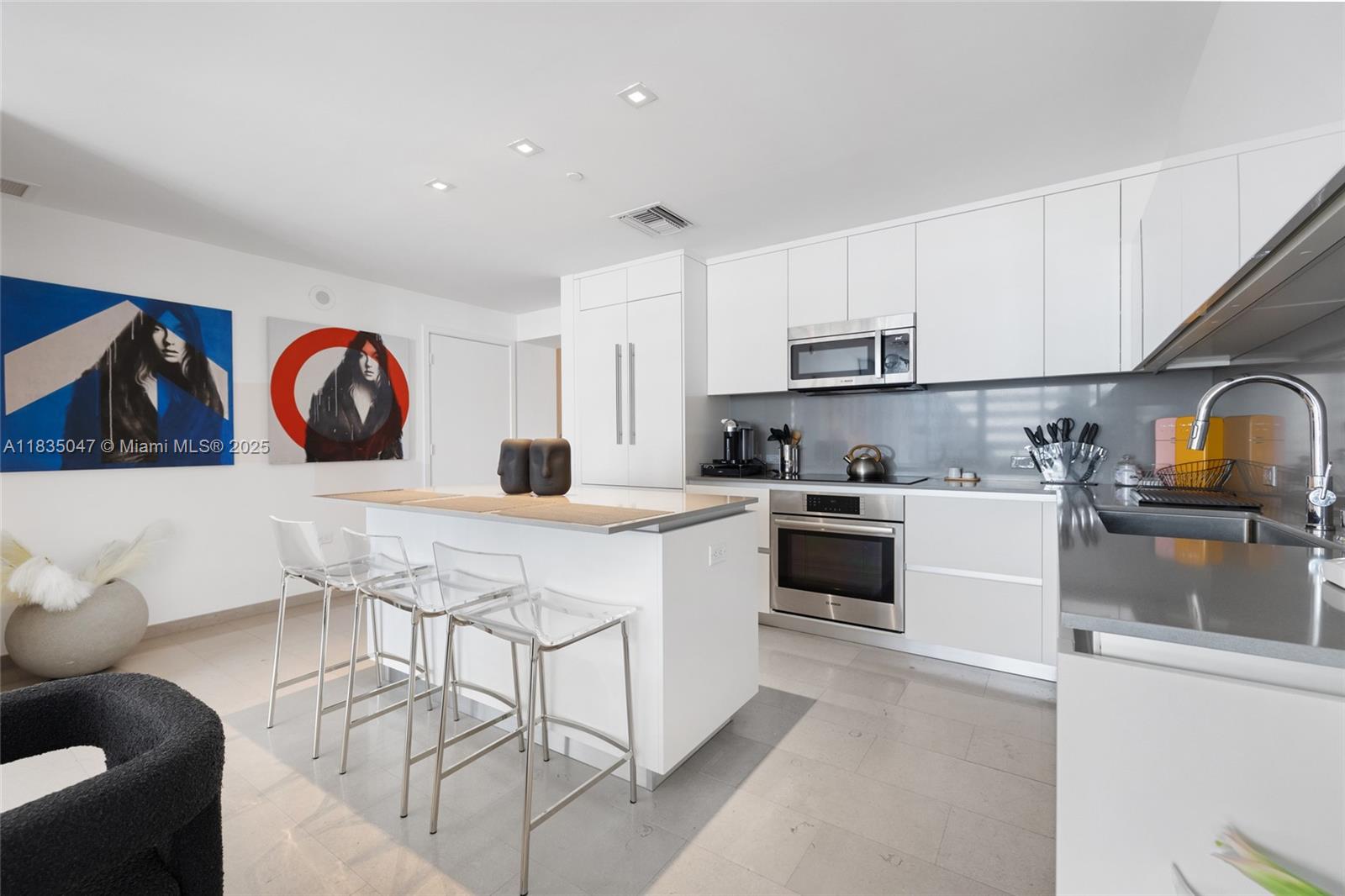 88 Southwest 7th Street, Unit 1010 Miami, FL 33130 - Photo 3 of 42 a kitchen with stainless steel appliances granite countertop a stove top oven a sink a refrigerator and white cabinets