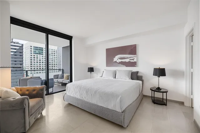 a bedroom with a bed couch and a large window