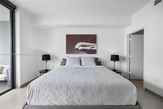 a bedroom with a bed and a painting on the wall