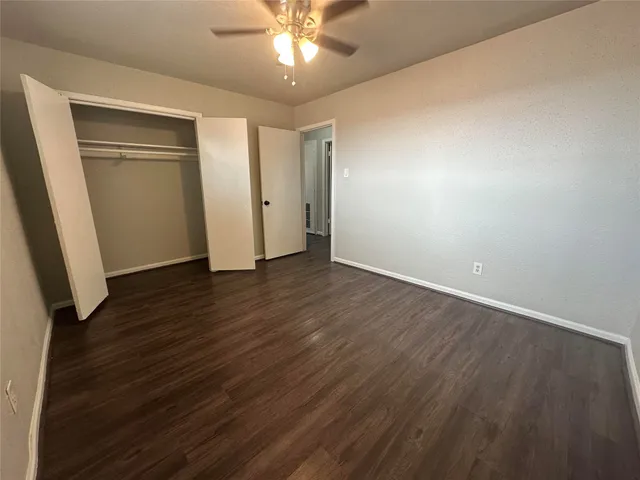 an empty room with wooden floor and entryway