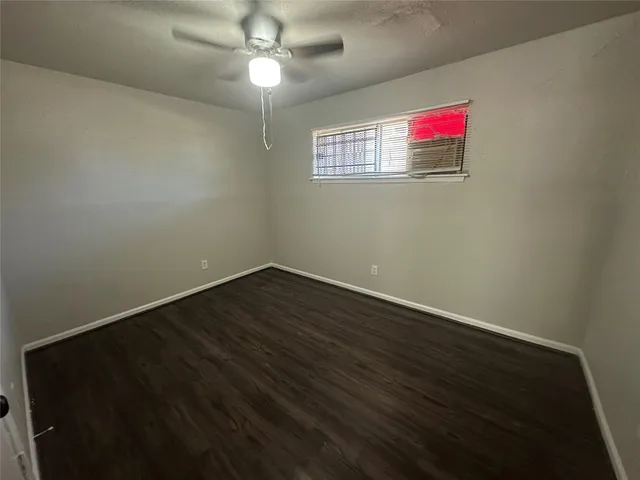 a view of a livingroom with wooden floor and a chandelier fan
