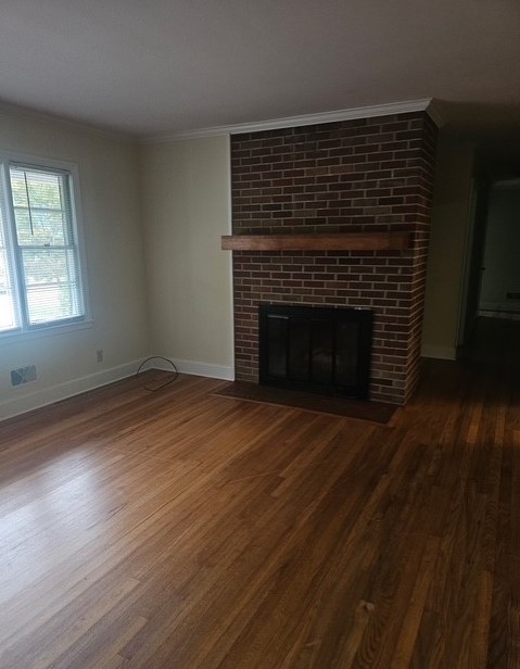 305 Augusta Road Clemson, SC 29631 - Photo 5 of 23 A welcoming living space features warm hardwood floors and a cozy brick fireplace.