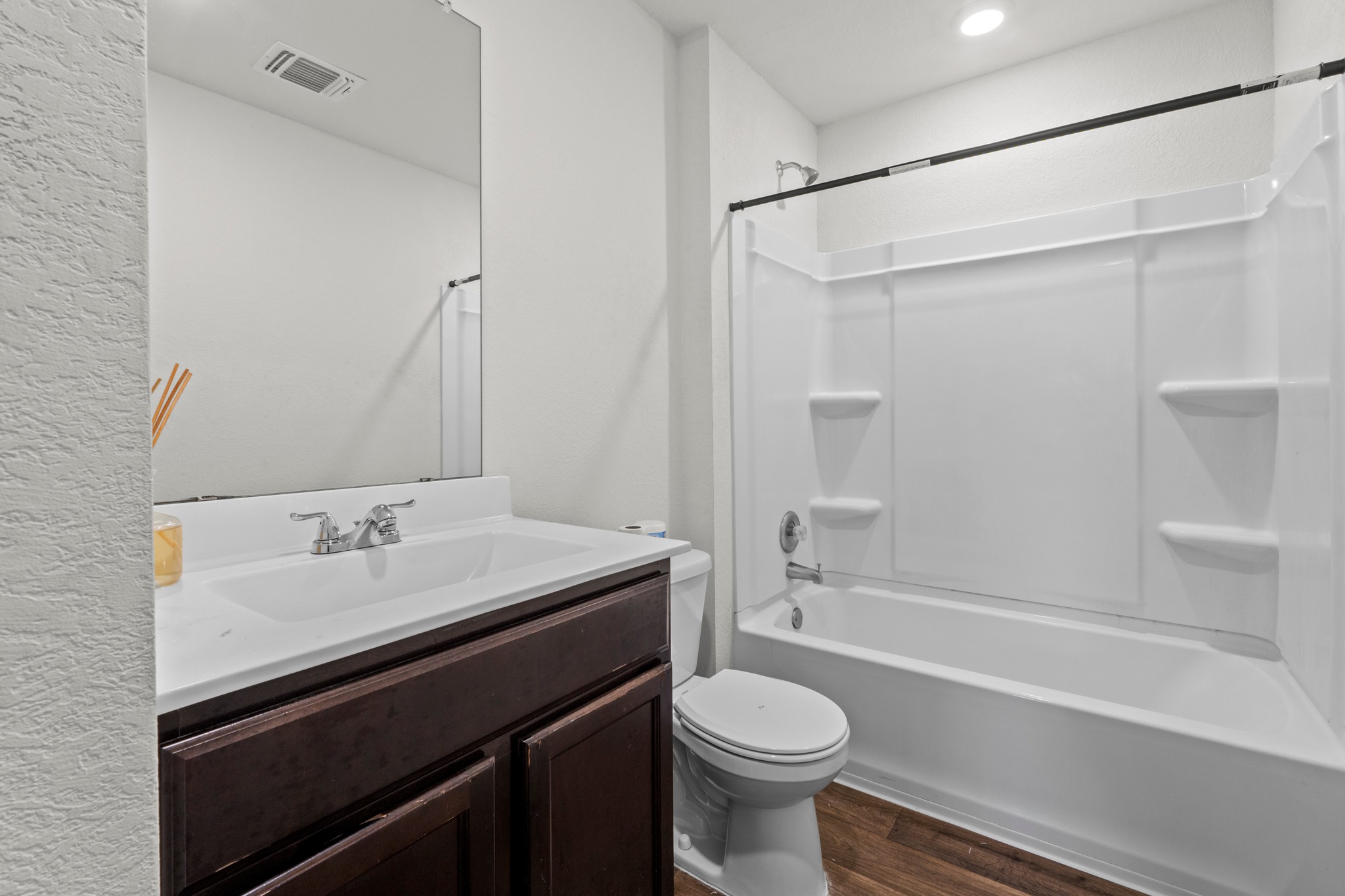 14917 Bajada Rd Manor Manor, TX 78653 - Photo 24 of 31 Bathroom featuring a dark wood-finish vanity, integrated white sink, chrome faucet, and a large wall-mounted mirror