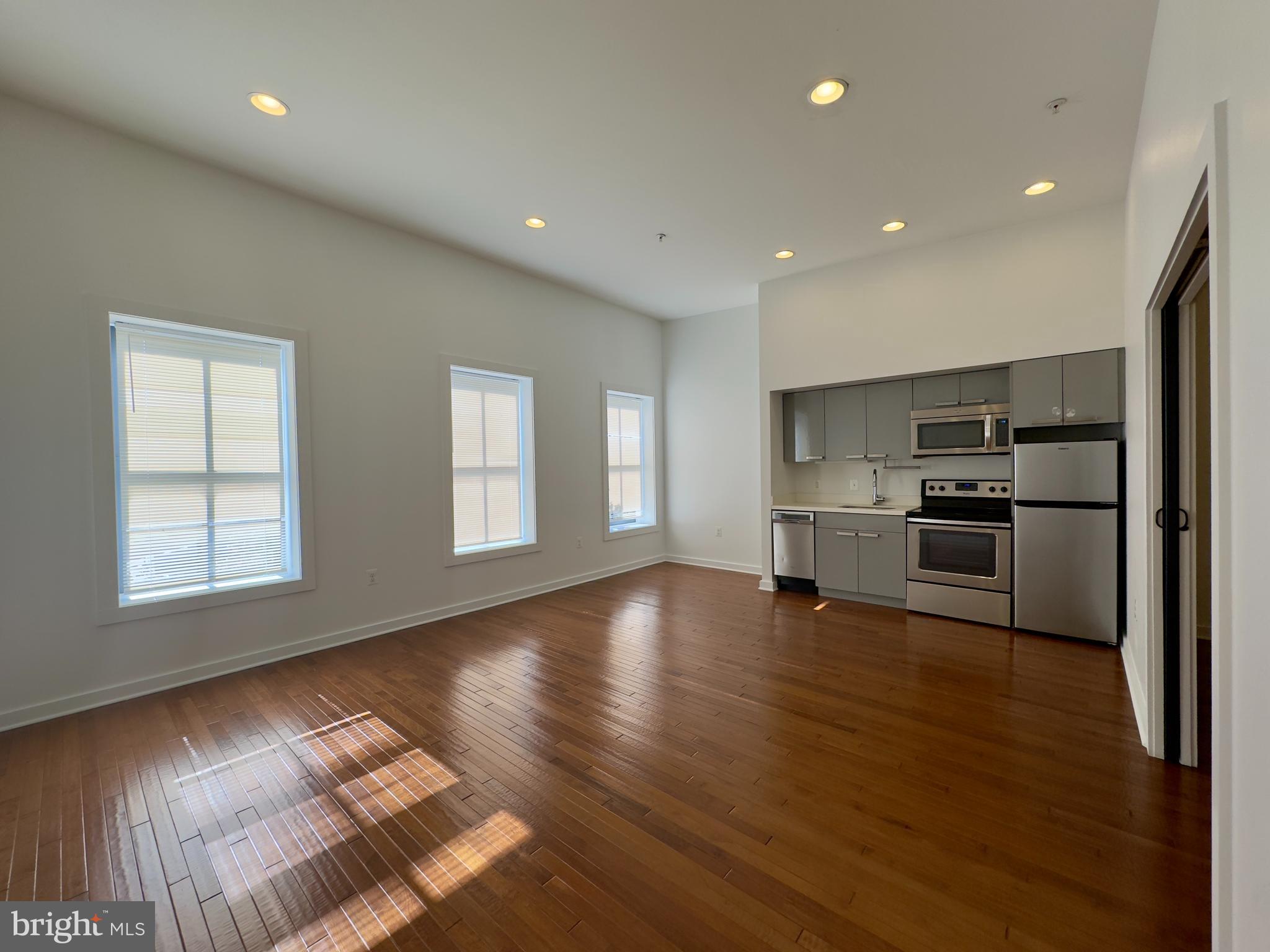613 Portland Street, Unit 30 Baltimore, MD 21230 - Photo 3 of 8 a view of empty room with wooden floor and kitchen