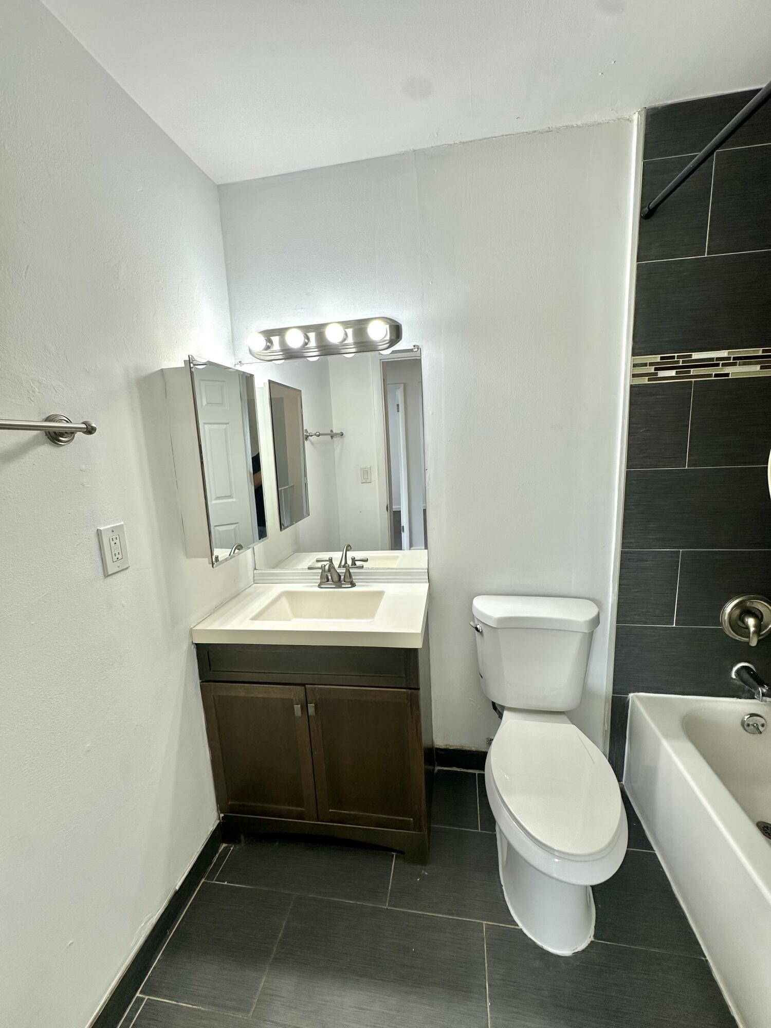 108 East Tiffany Drive, Unit 2 West Palm Beach, FL 33407 - Photo 12 of 14 a bathroom with a toilet sink and mirror