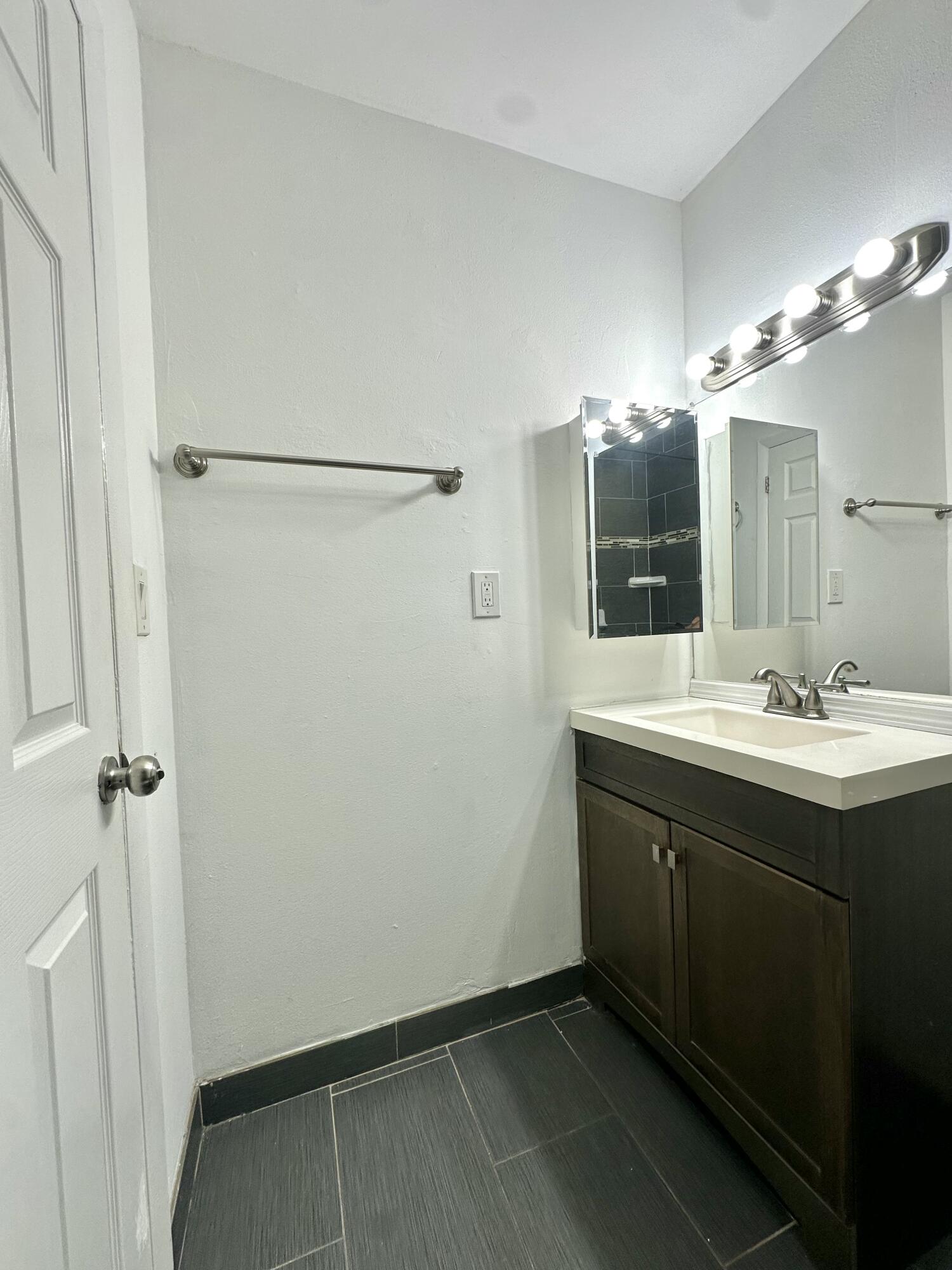108 East Tiffany Drive, Unit 2 West Palm Beach, FL 33407 - Photo 14 of 14 a bathroom with a sink and mirror