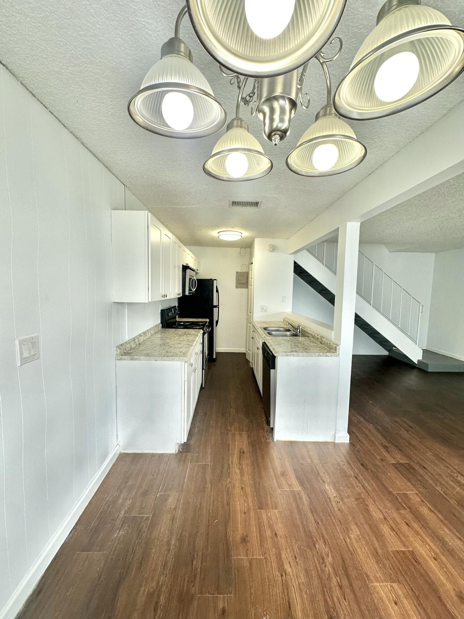 108 East Tiffany Drive, Unit 2 West Palm Beach, FL 33407 - Photo 4 of 14 a view of a kitchen with kitchen island and stainless steel appliances