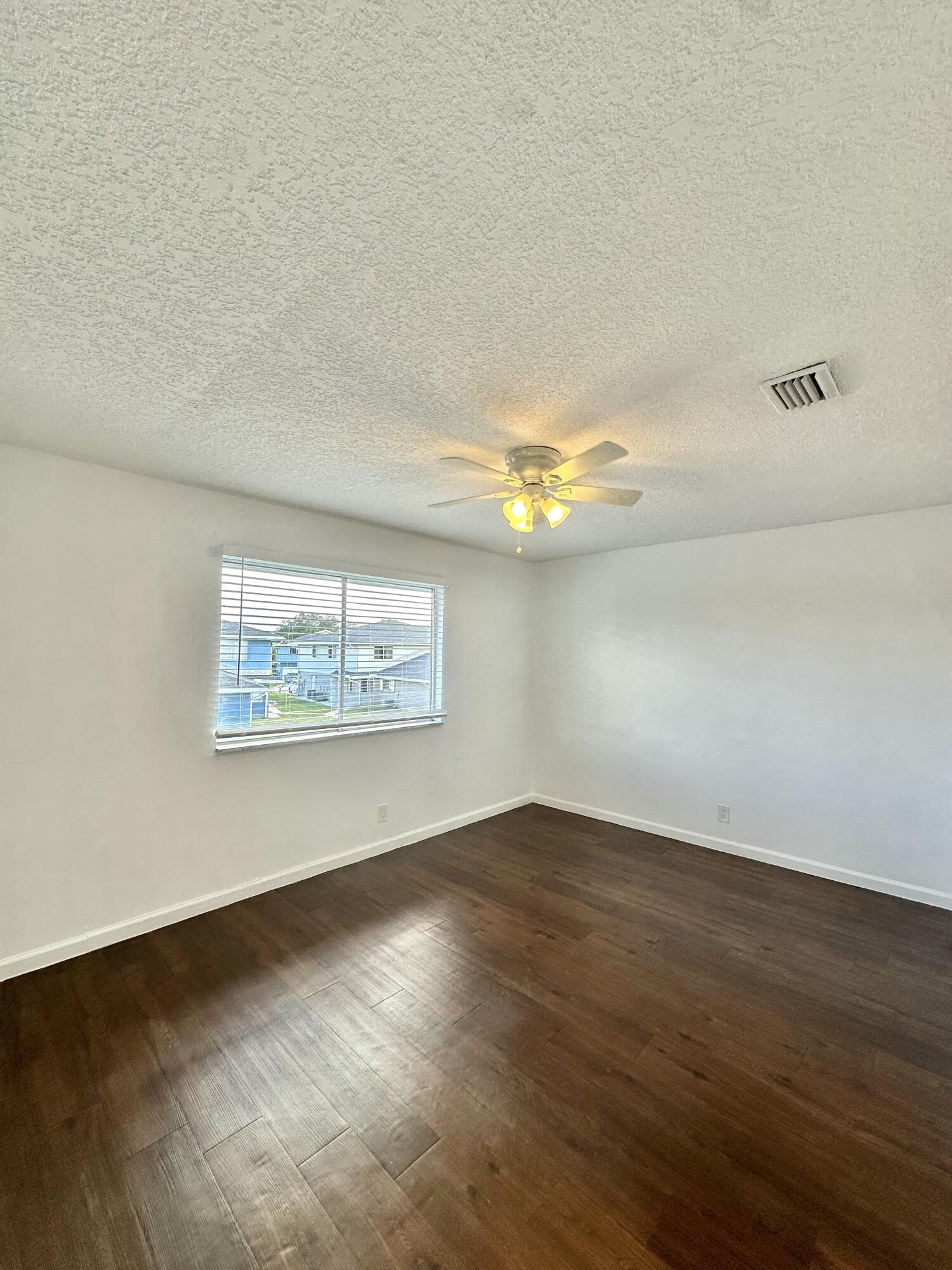 108 East Tiffany Drive, Unit 2 West Palm Beach, FL 33407 - Photo 7 of 14 a view of a room with wooden floor and white walls