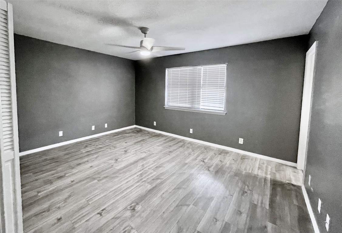 5929 Alsace Trail Austin, TX 78724 - Photo 13 of 18 an empty room with wooden floor and windows