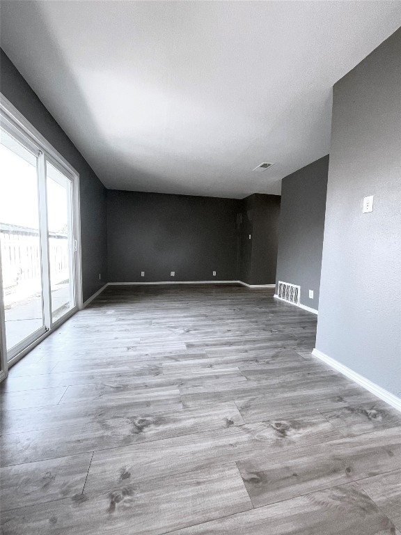 5929 Alsace Trail Austin, TX 78724 - Photo 2 of 18 an empty room with wooden floor and windows