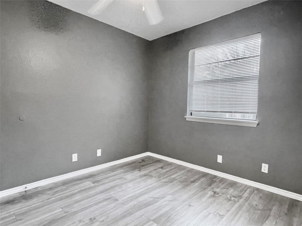 5929 Alsace Trail Austin, TX 78724 - Photo 10 of 18 a view of an empty room with wooden floor and a window