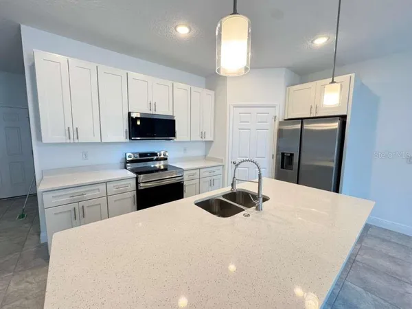 a kitchen with a appliances a sink and a refrigerator