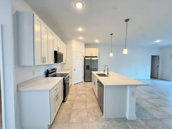 a large kitchen with kitchen island a sink a stove a center island a stove and a window