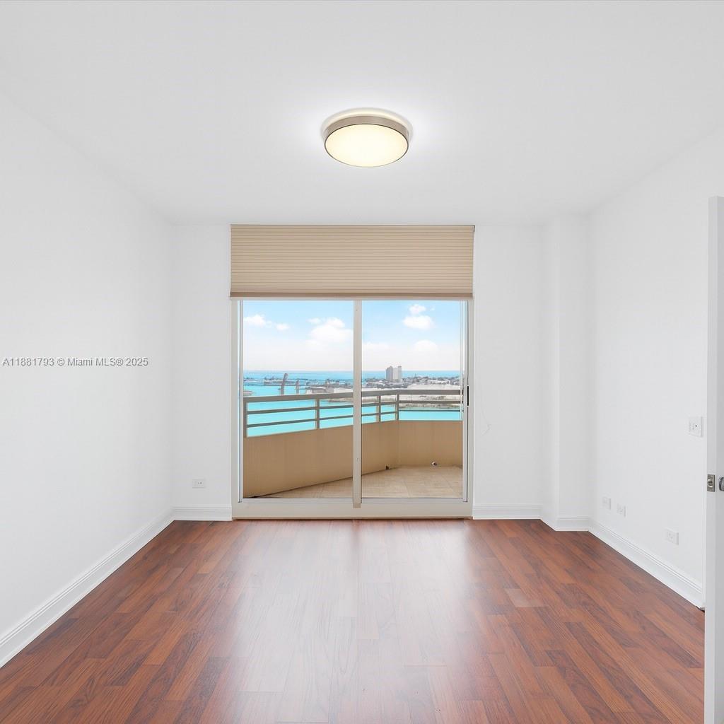 888 Brickell Key Drive, Unit 2510 Miami, FL 33131 - Photo 13 of 22 an empty room with wooden floor and fan