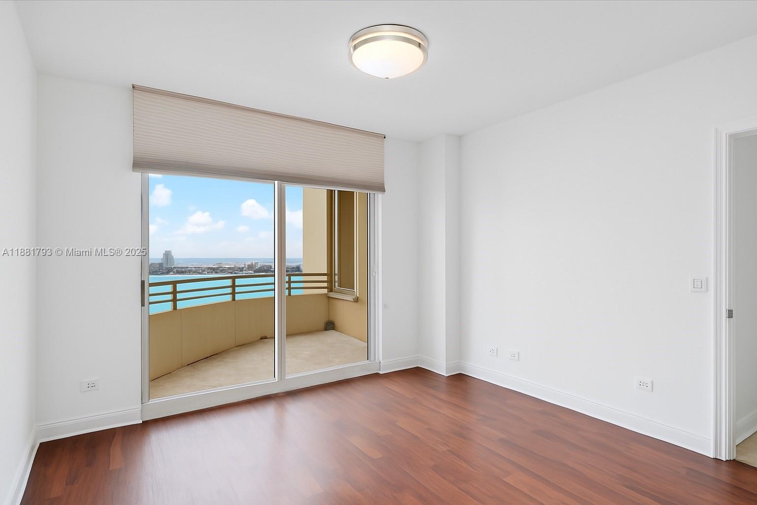 888 Brickell Key Drive, Unit 2510 Miami, FL 33131 - Photo 14 of 22 an empty room with wooden floor and windows